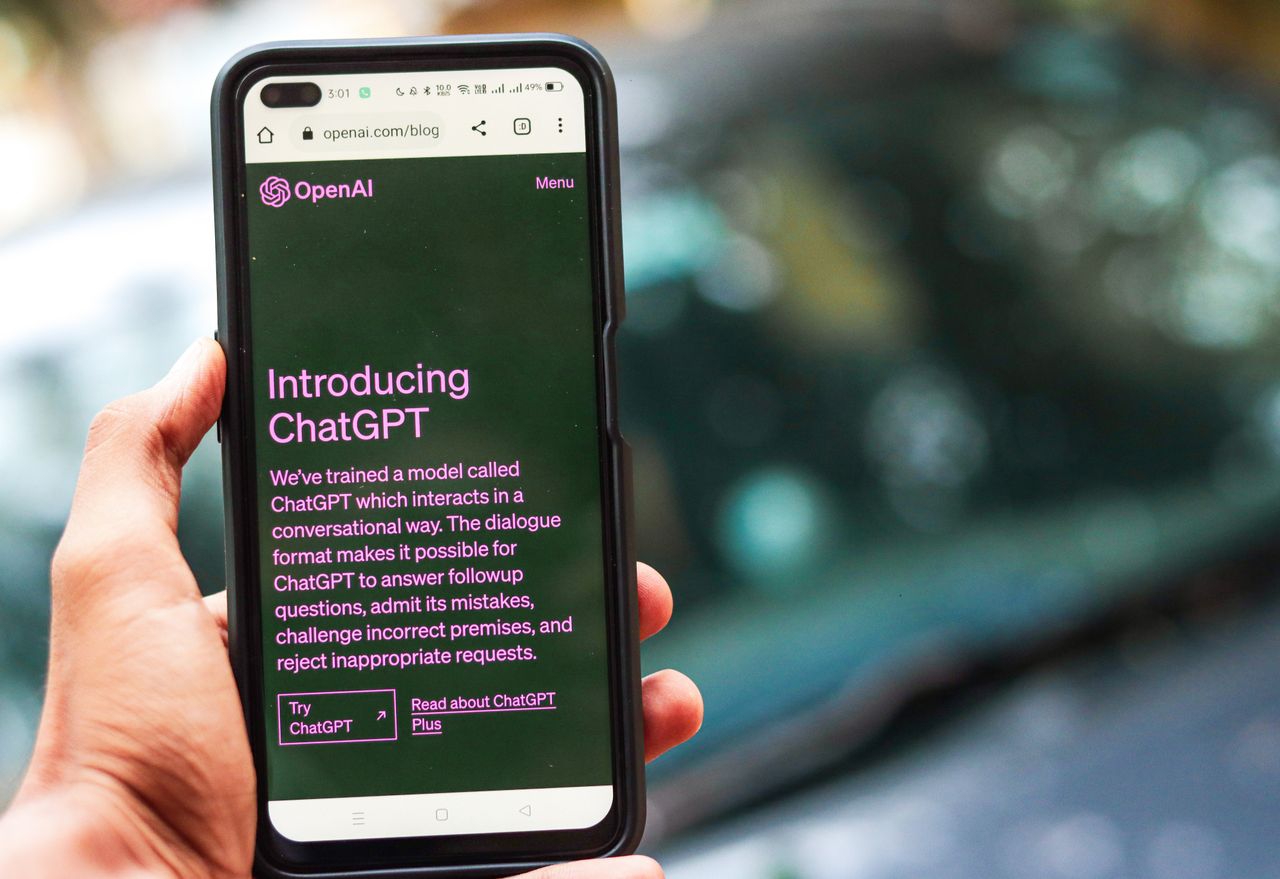 project-01-d Gros plan sur un smartphone affichant des détails sur ChatGPT sur le site d’OpenAI, tenu par une personne.